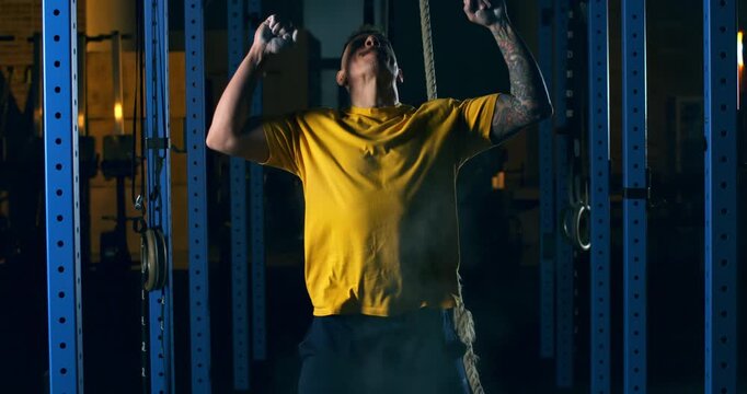 CrossFit Athlete Preparing Hands With Chalk and Exults Before Workout, Industrial Gym Atmosphere, Concept Of Ritual, Focus, Strength Building And Mental Preparation Before Challenge at 1000 fps