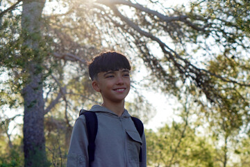 adventure and outdoor activities. Preteen boy hiking in a pine forest.