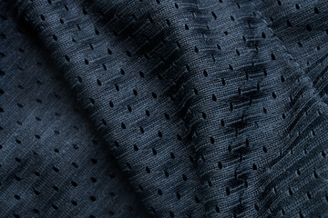 Black synthetic mesh fabric texture. Perforated polyester material for sportswear or lining. Macro background with ventilation holes. Photo