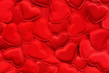 textile red hearts made of satin with a wavy border scattered on the surface