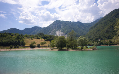 Lake Tenno in Italy has a small island and is located in a beautiful mountain landscape.