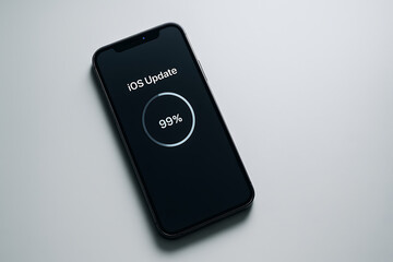 iOS update progress on smartphone screen showing ninety nine percent completion status concept representing modern mobile operating system upgrade installation process technology optimization security
