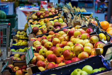 Fresh apples on display in a grocery store produce section