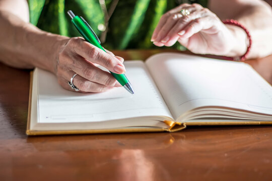 Senior hands writing daily notes in personal diary - Powered by Adobe