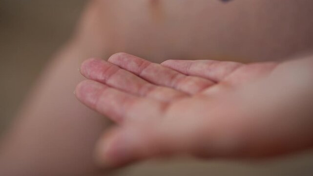 Female gently applying healing gel to significant bruise and hematoma on leg, carefully massaging ointment into injured area for initial treatment, close-up. Shooting in slow motion.