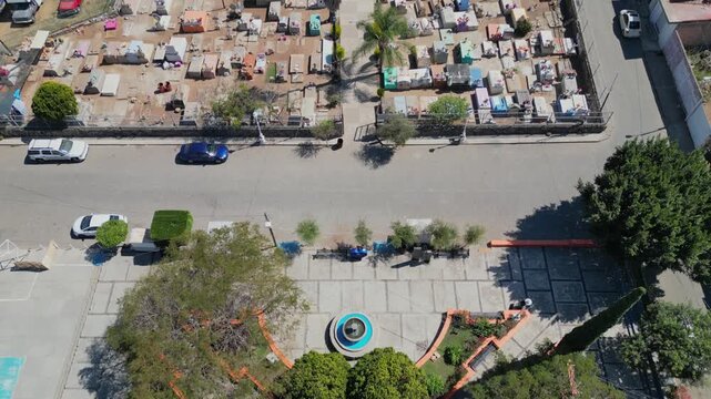 Aerial pan uncovering the stone church and wide atrium of San Lucas Evangelista with surrounding homes