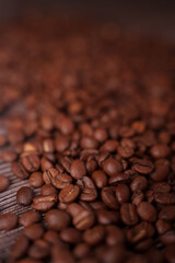 close-up view of scattered roasted coffee beans on wooden surface, showcasing rich textures and warm brown tones, emphasizing earthy aroma and flavor profile in moody setting, brew, cafe, espresso