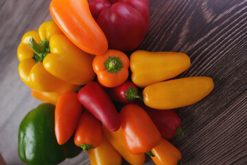vibrant array of multicolored bell peppers arranged on dark wooden surface capturing richness of colors and texture in fresh vegetable display, diet, vivid, delicious, cuisine, surface, smooth