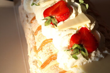 Cake with sliced red strawberries, whiped cream and meringue. Swedish pastry.