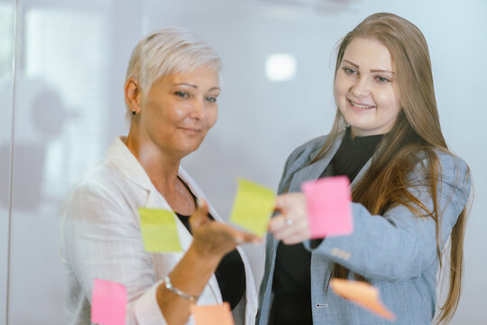 Business team analyzing data and marketing strategy in modern office, brainstorming ideas for project success using laptops and charts, teamwork collaboration for corporate growth
