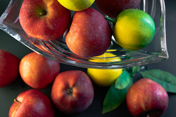 Still Life with Red Apples and Lemons in a Glass Vase on Black Background