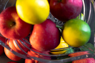 Still Life with Red Apples and Lemons in a Glass Vase on Black Background
