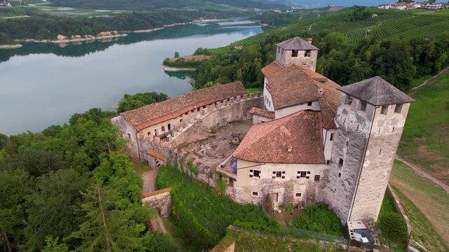 Medieval castles of northern Italy. scenic Cles castel- in Trentino , province of Trento. surrouded by fields of apple trees near the lake Santa Giustina, Non valley