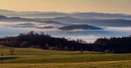 Misty Sunrise Over Layered Hills. Soft morning fog drapes across rolling hills at sunrise, creating dreamy layers of light and shadow in a tranquil. Perfect for nature and travel themes.

 
