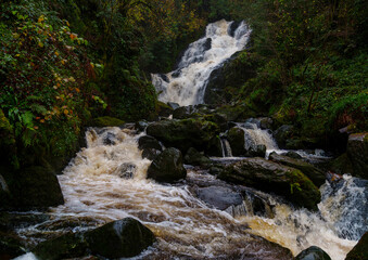 Obraz premium Torc Waterfall the ‘cascade of the wild boar,’ in Killarney National Park, County Kerry, Ireland, formed by the Owengarriff River draining from Devil’s Punchbowl at Mangerton Mountain.