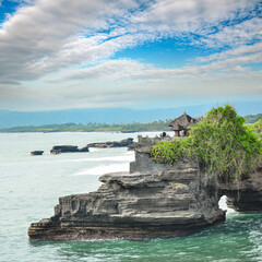 The natural rock arch at the Pura Batu Bolong near Tanah Lot Temple in Bali, Indonesia