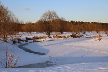 Snowy landscape with a river running through it