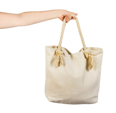 Isolated photo of female hand holding white cloth beach bag with copy space on white background.