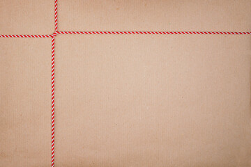 Red and White Christmas String Cross Tied on Kraft Paper Background