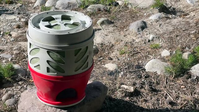 Life at a tourist camp. Emptying the remaining gas from a gas cylinder at a camp in the Caucasus Mountains. Life in the wild. Man and nature