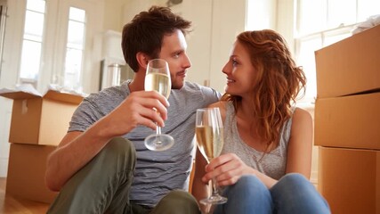 Toast to a New Beginning: A couple, surrounded by moving boxes, celebrates their new home with a toast, their eyes meeting in a moment of shared joy and excitement. 