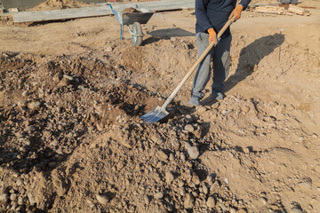 Man is digging a hole in the dirt with a shovel