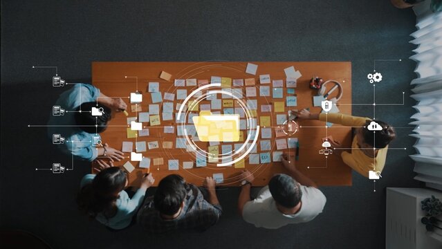 An overhead view of a collaborative meeting where professionals brainstorm ideas using sticky notes in a modern workspace setting, showcasing technology and teamwork. Raster