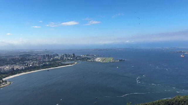 Panoramic view f in Rio de Janeiro, Brazil, overlooking Guanabara Bay, Santos Dumont Airport, the distant Rio&ndash;Niter&oacute;i Bridge, and  urban areas under partly cloudy daylight.