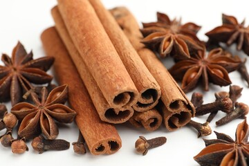 Mulled wine spices. Cinnamon sticks, anise stars and cloves on white wooden table, closeup