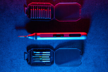 Precision screwdriver set highlighted on textured dark background, Showcase of electric screwdriver and accessories with professional studio lighting and reflections