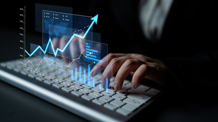 A close-up view of hands typing on a keyboard, with an overlay of virtual graphs and data visualizations, illustrating business growth and analytics in a modern setting. Scalp