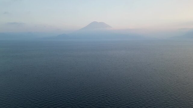 beautiful sunset views on lake atitlan volcanic water in guatemala central america travel tourism destination drone aerial view flying serene still stunning volcano mist clouds relax relaxing