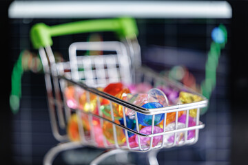 Colorful diamonds gemstones in shopping cart with stock market graph background