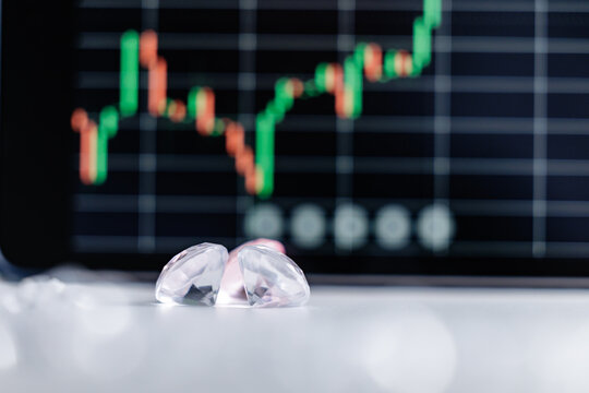Closeup of diamonds with blurred stock market graph in background - Powered by Adobe