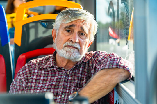 Senior man riding bus looking at camera - Powered by Adobe