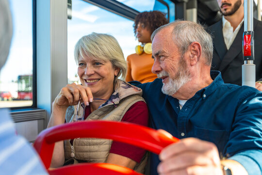 Senior couple enjoying public transport travel by bus together