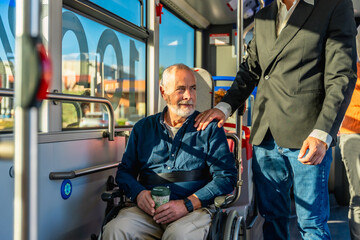 Man in wheelchair on bus receiving support © unai