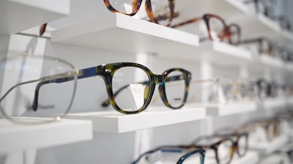 Assortment of designer glasses and spectacles displayed on a pristine white shelf at an eyewear boutique. Choose from a wide variety of trendy frames available for purchase