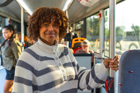 Young woman smiling, commuting on public transportation bus - Powered by Adobe