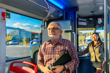 Senior man smiling while commuting on public bus