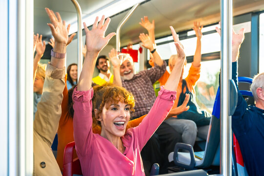 Diverse group of people celebrating and cheering on bus