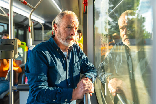 Senior man commuting on bus looking thoughtful