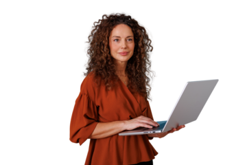 Mature woman with curly hair standing, holding a laptop, typing and looking away, representing professional work