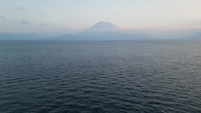 beautiful sunset views on lake atitlan volcanic water in guatemala central america travel tourism destination drone aerial view flying serene still stunning volcano mist clouds relax relaxing