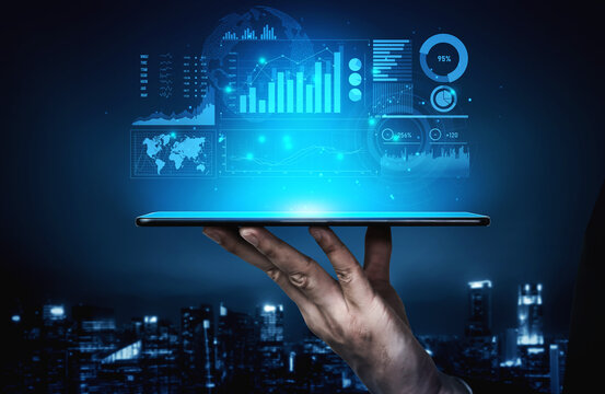 A hand holds a tablet showcasing a vibrant digital interface of data analytics and business insights against a night city background. Ideal for technology themes. Scalp
