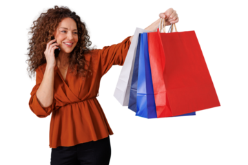 Woman holding colorful shopping bags while talking on a mobile phone, smiling and enjoying the experience of consumerism