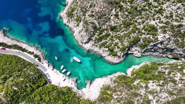 Aerial drone video of of Porto Stenitis famous fjord shaped bay with crystal clear turquoise sea and small beach  ideal for snorkeling visited by small tourist boats, Zakinthos island, Ionian, Greece