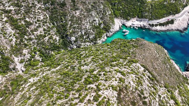 Aerial drone video of of Porto Stenitis famous fjord shaped bay with crystal clear turquoise sea and small beach  ideal for snorkeling visited by small tourist boats, Zakinthos island, Ionian, Greece