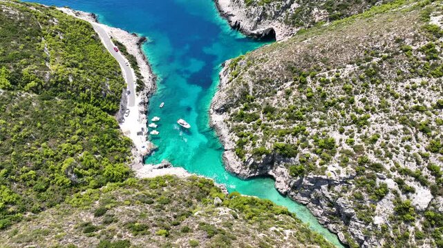 Aerial drone video of of Porto Stenitis famous fjord shaped bay with crystal clear turquoise sea and small beach  ideal for snorkeling visited by small tourist boats, Zakinthos island, Ionian, Greece
