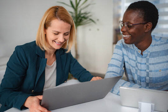 Diverse businesswomen collaborating and smiling during office meeting